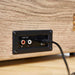 A close-up view of the line-out ports on the back of Arkrocket Curiosity Suitcase Bluetooth Turntable (Wood Grain) showing connections for external audio