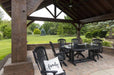 A comfortable black chair with a “Family” pillow sits under the Brookside Timber Frame Timber Retreat Pavilion