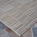 A corner angle shot of the Couristan Cape Indoor/Outdoor Rug - Fayston/Silver-Charcoal emphasizes the natural and silver tones woven into its clean edges
