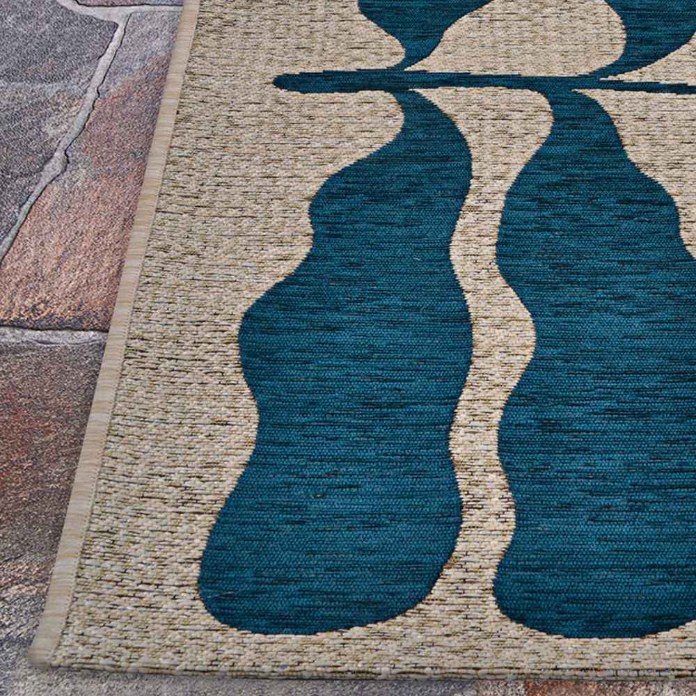 A corner close-up of the Couristan Castille Indoor/Outdoor Rug - Fiore/Petrol highlights its clean border and the clarity of its flowing leaf motif