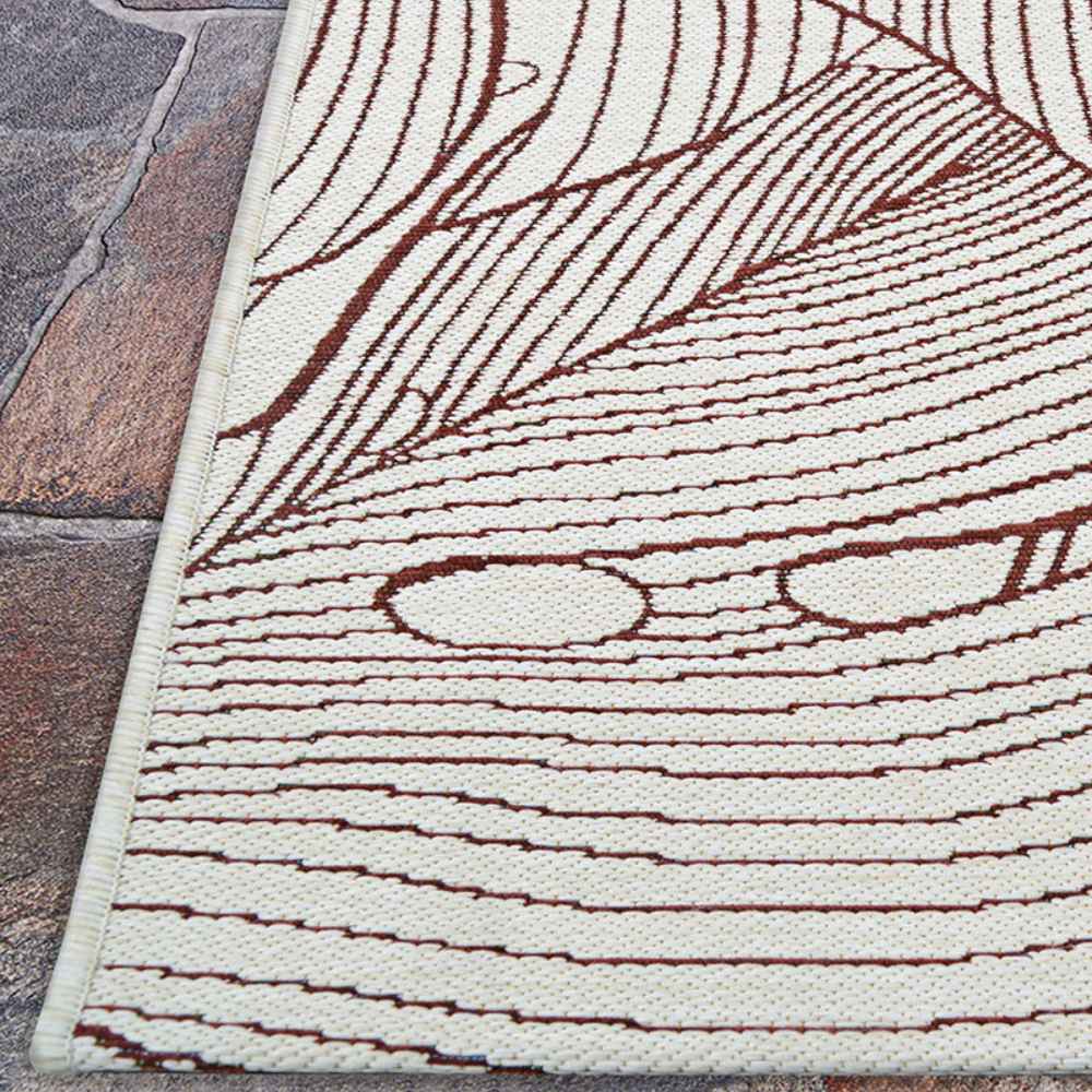 A corner of the Couristan Castille Indoor/Outdoor Rug - Palma/Rouge is shown flat on stone flooring