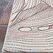 A corner of the Couristan Castille Indoor/Outdoor Rug - Palma/Rouge is shown flat on stone flooring