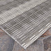 A corner view of the Couristan Cape Indoor/Outdoor Rug - Torrent/Sky Blue-Grey lies flat over a stone surface