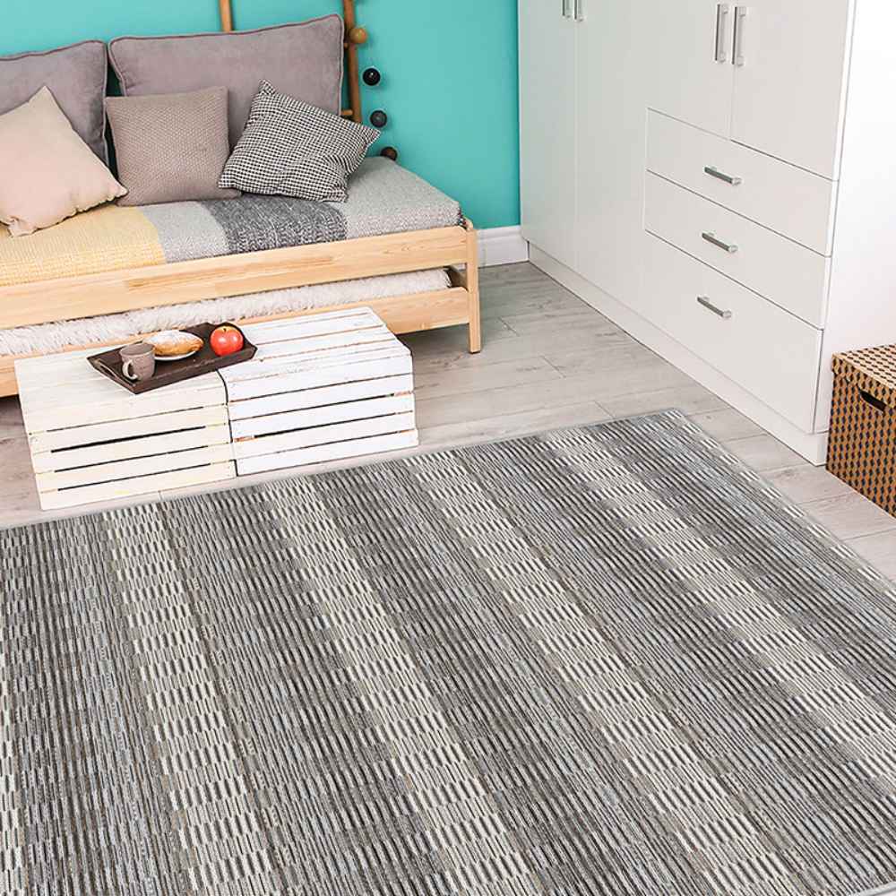 A cozy room features the Couristan Cape Indoor/Outdoor Rug - Torrent/Sky Blue-Grey with subtle striped patterns adding texture to the light wood floor