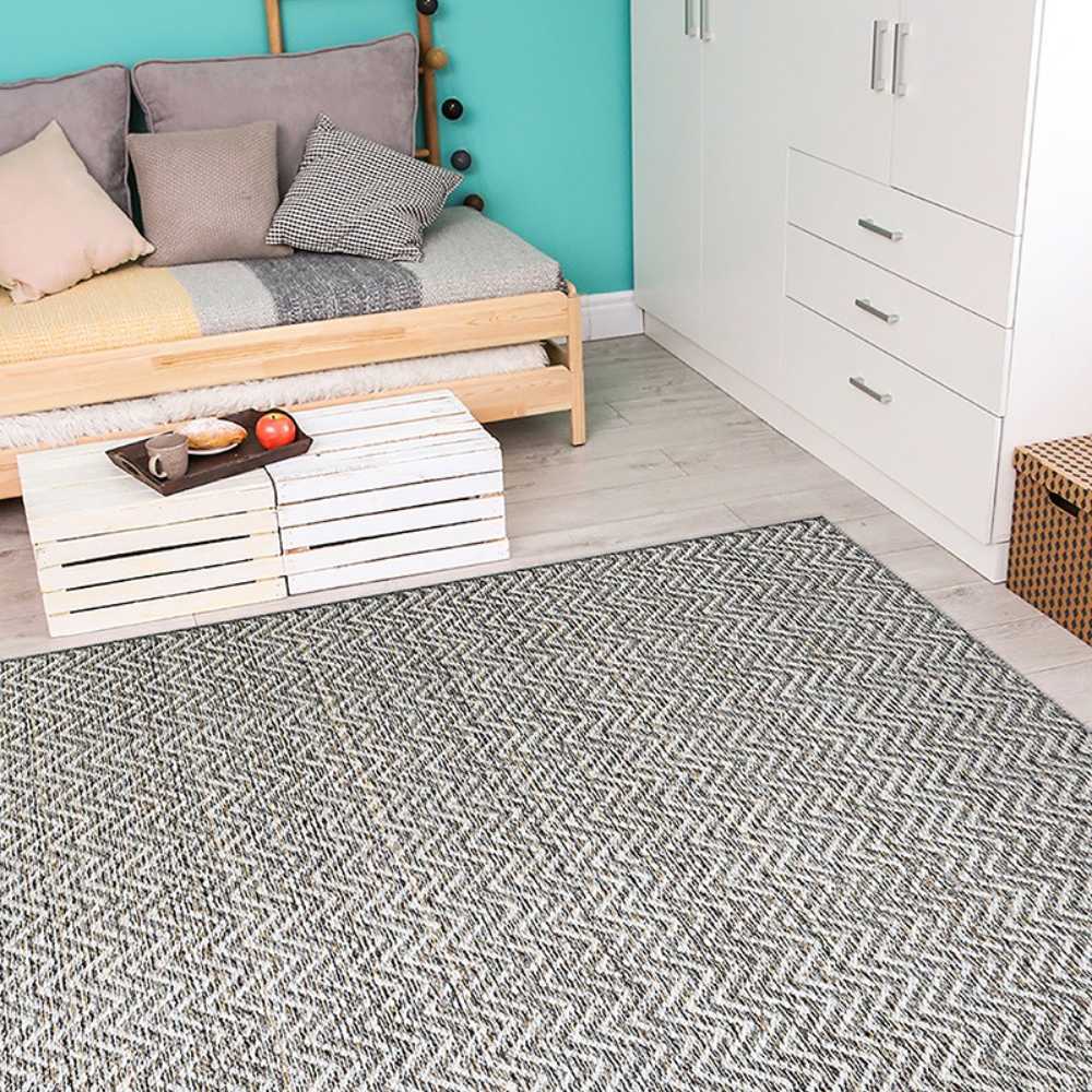 A cozy room scene features the Couristan Cape Indoor/Outdoor Rug - Marion/Light Brown-Ivory laid out in front of a couch and coffee table on light wood flooring