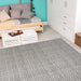A cozy room scene features the Couristan Cape Indoor/Outdoor Rug - Marion/Light Brown-Ivory laid out in front of a couch and coffee table on light wood flooring