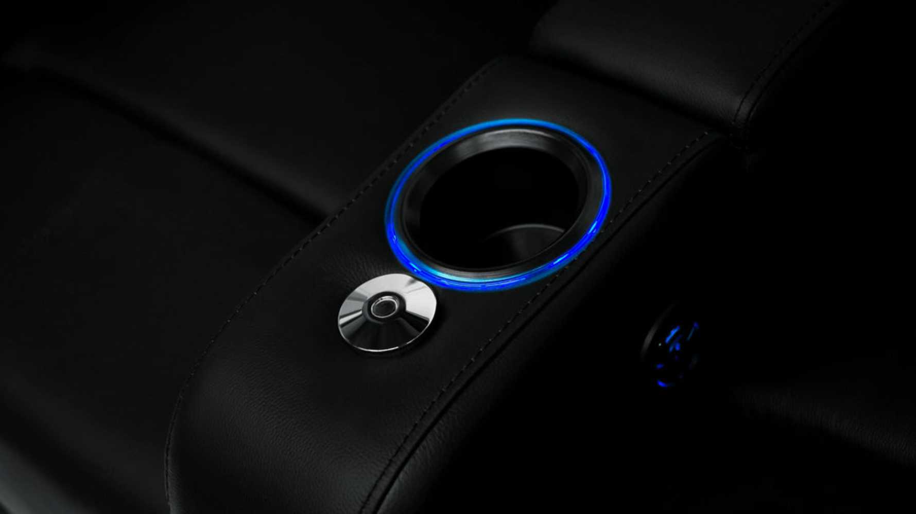 A cup holder with blue ambient lighting in the Valencia Piacenza Power Headrest Edition Home Theater Seating