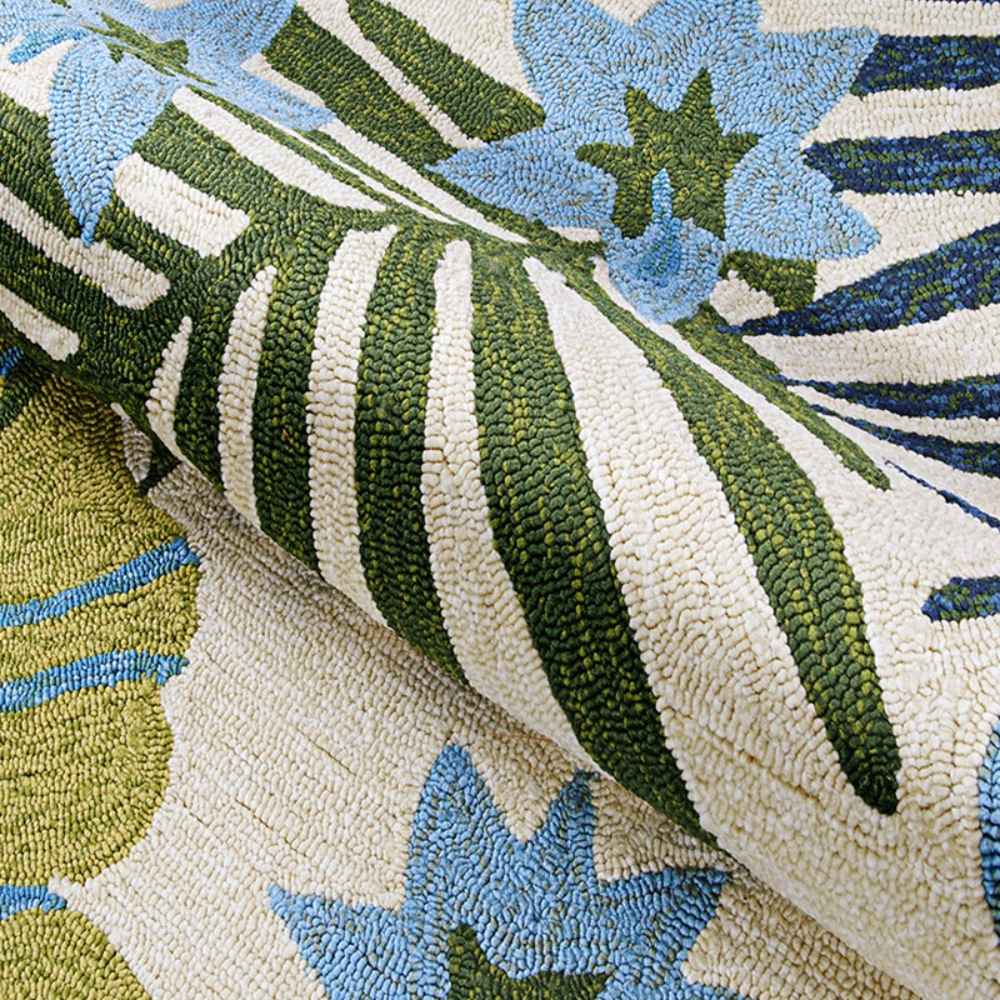 A curled edge reveals the dense hooked surface of the Couristan Covington Indoor/Outdoor Rug - Summer Laelia/Ivory-Fern with bright tropical florals