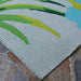 A detailed corner shot of the Couristan Covington Indoor/Outdoor Rug - Flamingos/Multi displays the dense tufted loops and vivid green leaf design