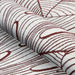 A detailed view of the Couristan Castille Indoor/Outdoor Rug - Palma/Rouge shows its rolled-up texture and flowing leaf-like red line pattern on white