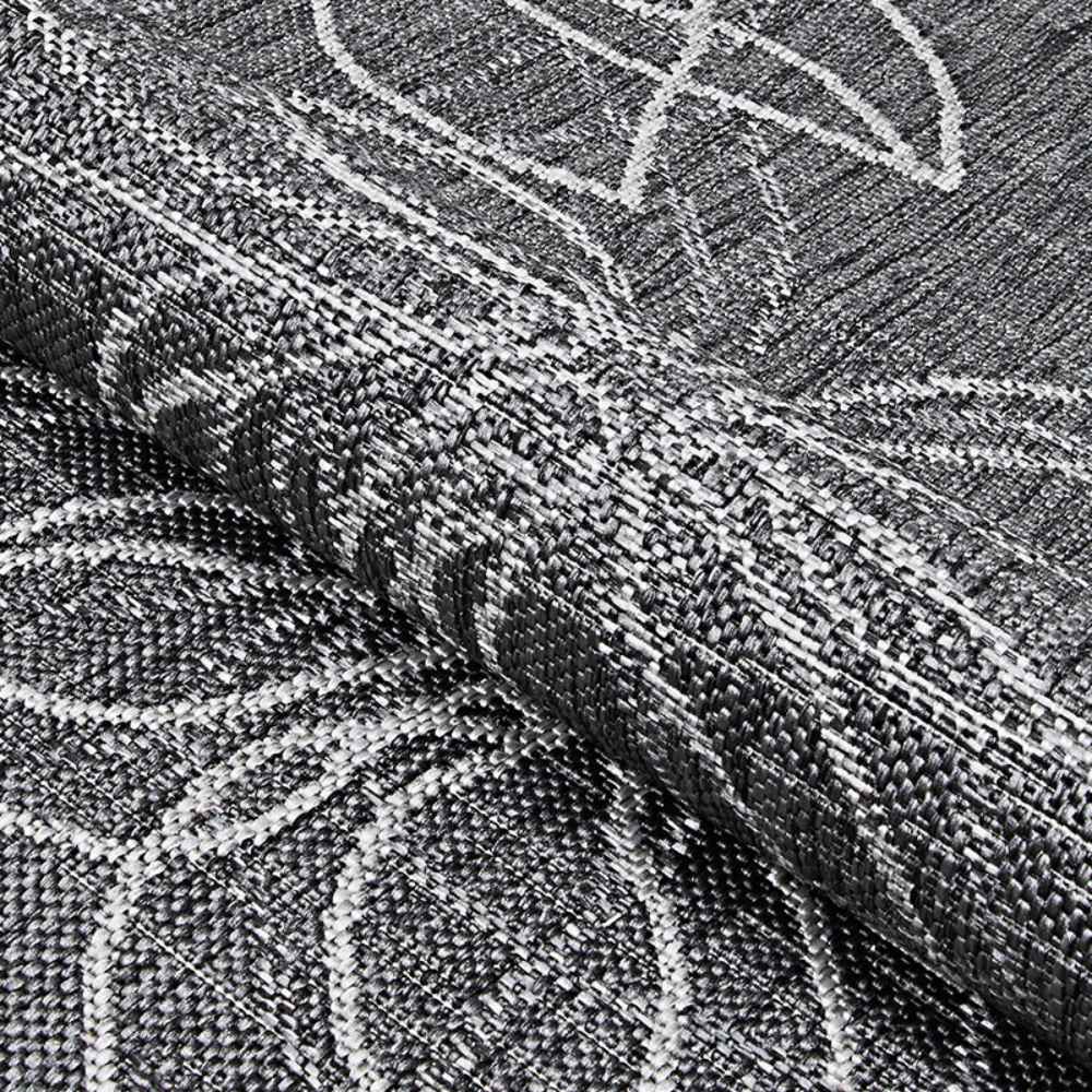 A folded corner of the Couristan Charm Indoor/Outdoor Rug - Botanical/Ash highlights the tightly woven texture and high-quality craftsmanship