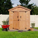 A front view of the Outdoor Living Today SpaceMaster 6×4 with Double Door shows a wooden shed with double doors, black handles, and a pitched roof standing on a green lawn