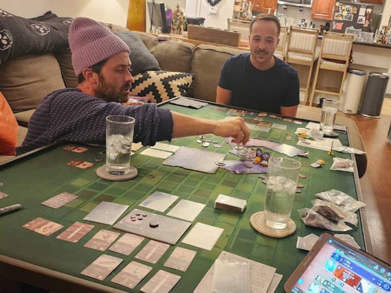 A group of friends intensely playing a board game on the Game Theory Tables The Origins Coffee Table