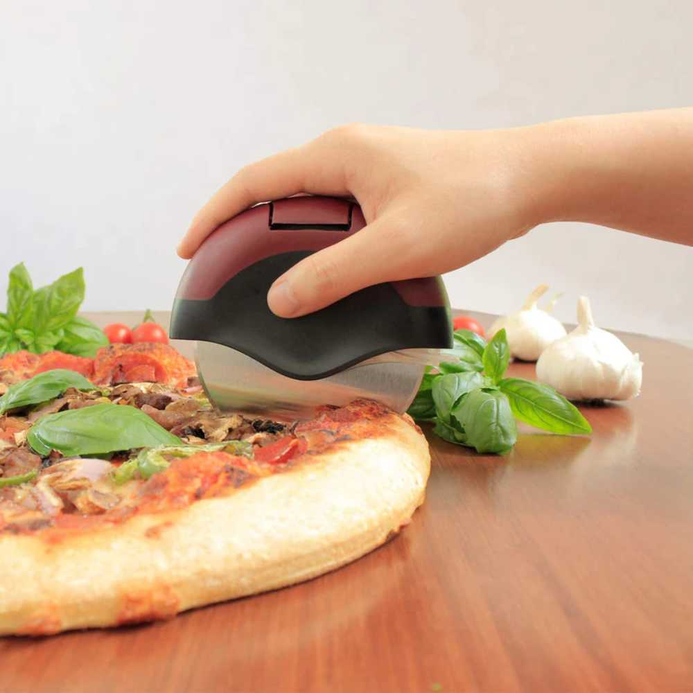 A hand smoothly glides the Chicago Brick Oven Pizza Cutter with Cover over a pizza