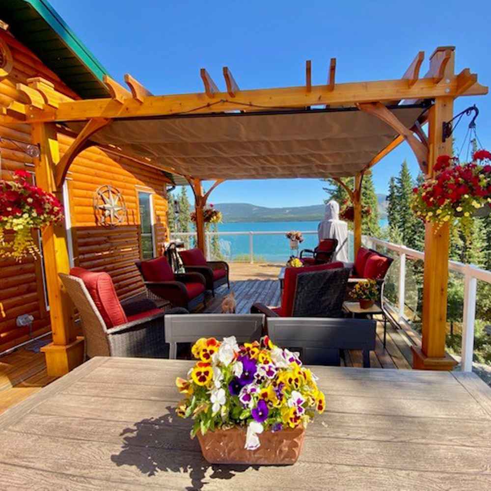 A lakeside patio beautifully enhanced by the Outdoor Living Today Western Red Cedar Pergola & Canopy with comfortable seating beneath