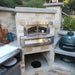 Alfresco Grills 30 Pizza Oven Plus - Built-In is seamlessly built into a modern outdoor kitchen, surrounded by a Big Green Egg and countertop prep space