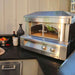 Alfresco Grills 30 Pizza Oven Plus - Countertop Model sits stylishly on an outdoor kitchen counter