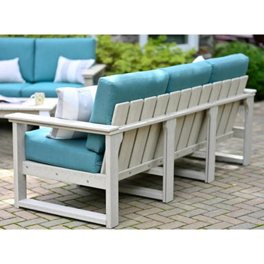 A light-colored poly lumber outdoor sectional with turquoise cushions, highlighting the LuxCraft Armrest and Center Support.