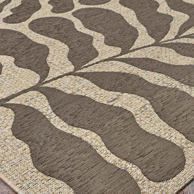 A low-angle shot captures the soft curves and mocha tones of the Couristan Castille Indoor/Outdoor Rug - Fiore/Mocha up close