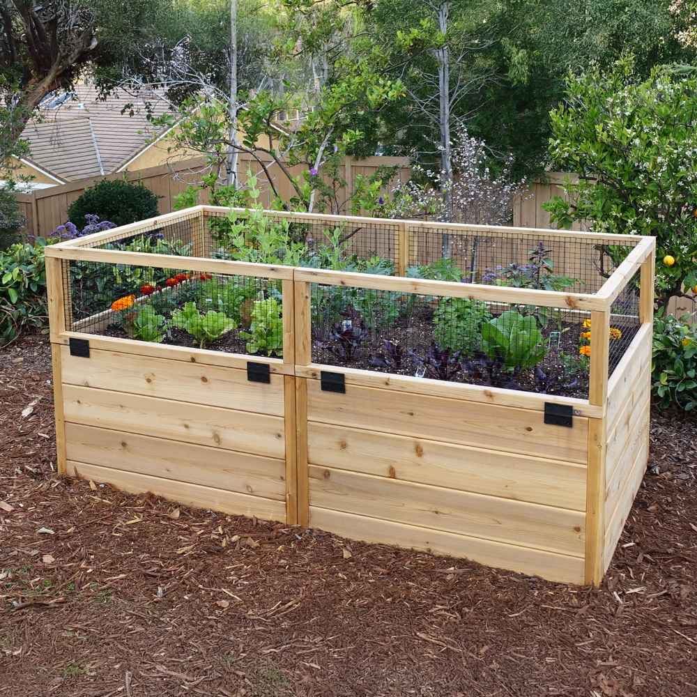 A lush garden area displays an Outdoor Living Today 6×3 Raised Garden Bed with plants growing securely behind a mesh fence