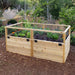 A lush garden area displays an Outdoor Living Today 6×3 Raised Garden Bed with plants growing securely behind a mesh fence