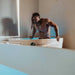 A muscular individual steps out of a Dreampod Ice Bath with Chiller indoors