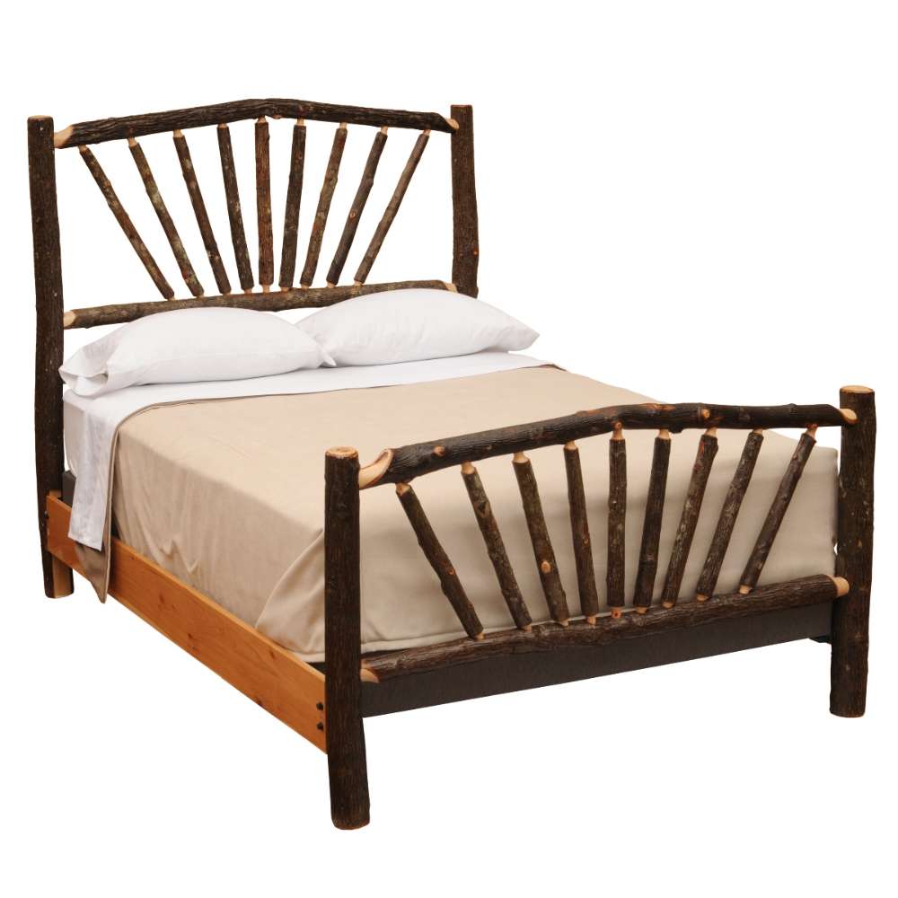 An angled studio shot of the Fireside Lodge Hickory Log Sunburst Bed with bedding, clearly showing the natural log posts and sunburst spindle design