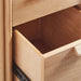 An open storage drawer of Crate & Barrel Elias 66" Natural Elm Wood Desk with File Cabinet shows its spacious interior for office essentials