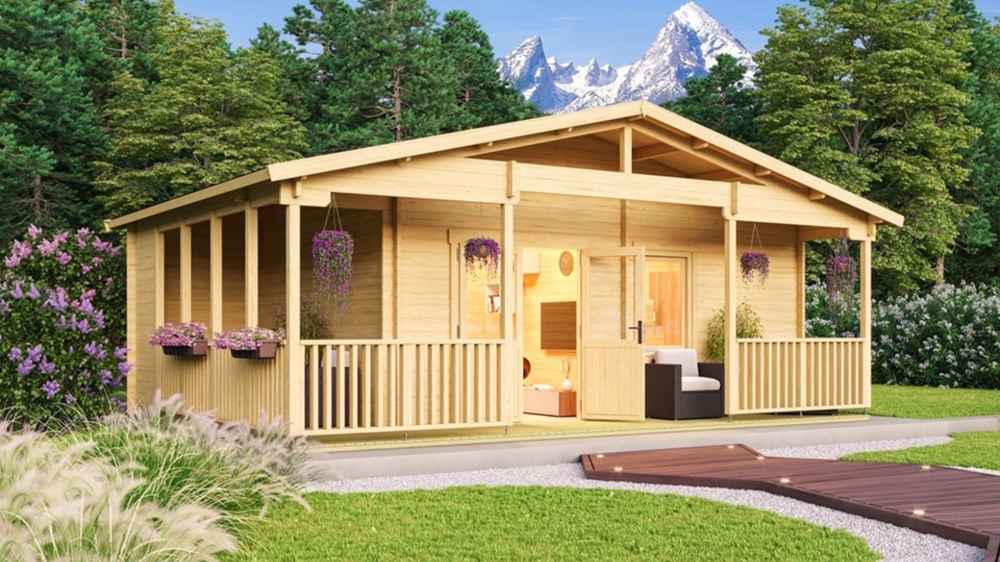 An angled exterior shot of the GardenHouse24 USA Glostrup 70 Garden Room highlights its spacious wraparound porch and wooden frame nestled in lush greenery