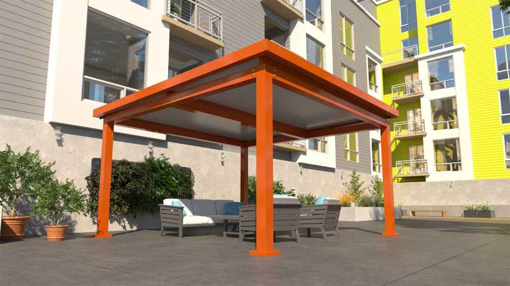 An orange Structureworks Pavilion Trex Pergola is set on a patio with outdoor seating, in front of a colorful apartment building