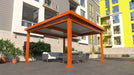 An orange Structureworks Pavilion Trex Pergola is set on a patio with outdoor seating, in front of a colorful apartment building