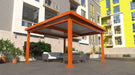 An orange Structureworks Pavilion Trex Pergola is set on a patio with outdoor seating, in front of a colorful apartment building