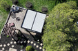 An aerial view showcases the Brookside Timber Frame Zion Resort Pergola, beautifully integrated into a landscaped backyard with a fire pit and seating area