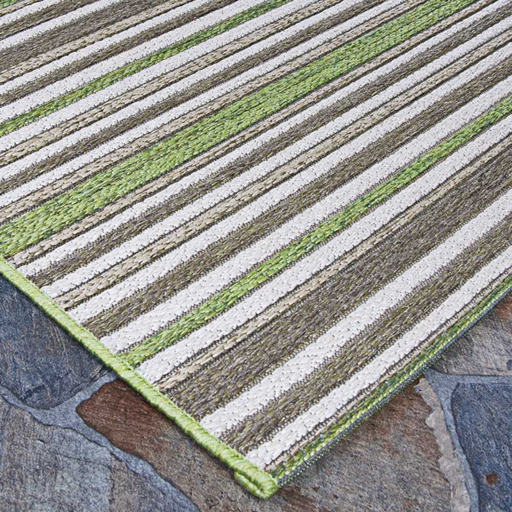 An angled shot displays the edge and surface of the Couristan Cape Indoor/Outdoor Rug - Brockton/Hunter Green-Brown on a slate floor