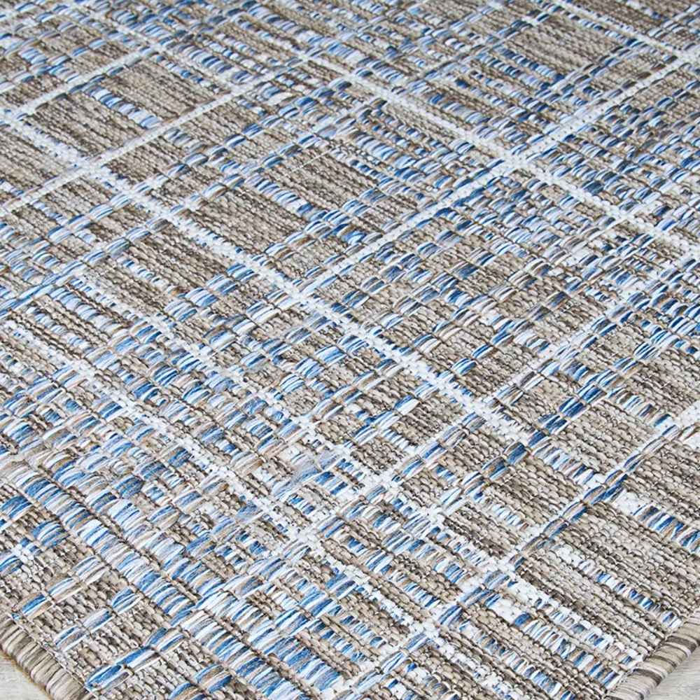 An angled view of the Couristan Charm Indoor/Outdoor Rug - Ohe/Sand-Ivory shows the raised woven lines and soft color transitions across the surface