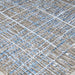 An angled view of the Couristan Charm Indoor/Outdoor Rug - Ohe/Sand-Ivory shows the raised woven lines and soft color transitions across the surface