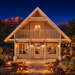Front-facing Anders 90A entertainment studio glowing brightly at night as friends watch sports, framed by illuminated desert landscaping and Arizona red-rock formations.