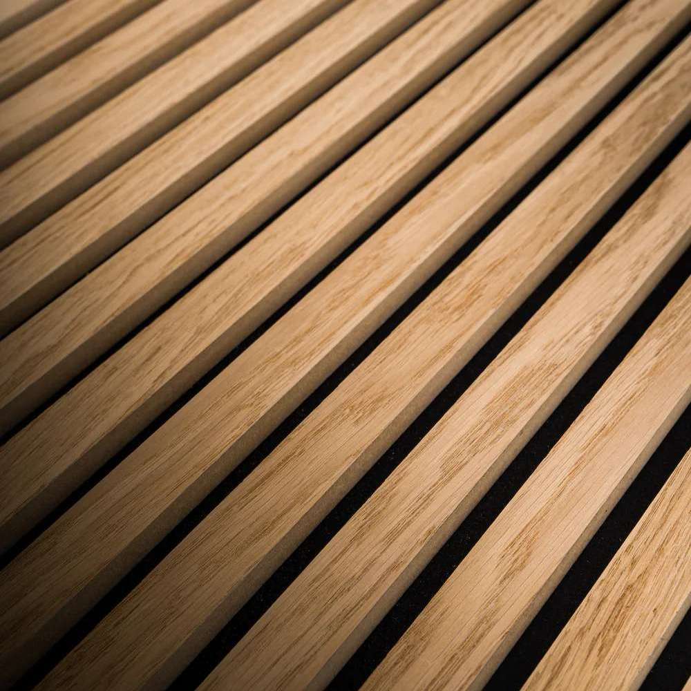 Angled close-up of GIK Acoustics SlatFusor™ Polycylindrical Diffuser emphasizing the depth, texture, and spacing of the wooden slats over a dark backing