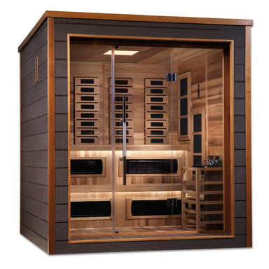 Angled from the left, Golden Designs Karlstad 6 Person Outdoor-Indoor PureTech Hybrid Full Spectrum Sauna shows its dark side wall, glass front and two-level cedar benches with a guarded stove