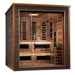 Angled from the left, Golden Designs Karlstad 6 Person Outdoor-Indoor PureTech Hybrid Full Spectrum Sauna shows its dark side wall, glass front and two-level cedar benches with a guarded stove