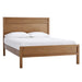 Angled view of Crate & Barrel Keane Solid Driftwood Queen Bed with a tall headboard, solid wood frame, and white bedding