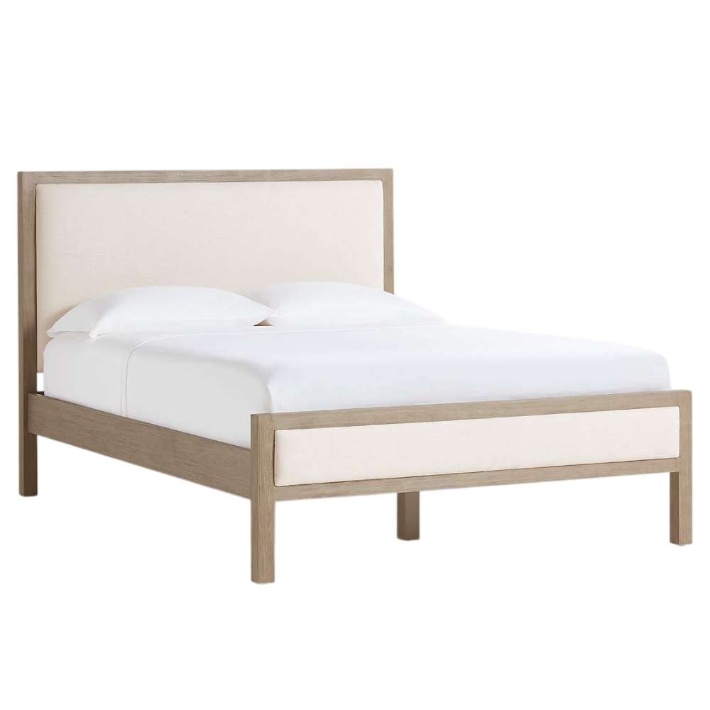 Angled view of Crate & Barrel Keane Weathered Natural Wood Upholstered Queen Bed featuring a weathered natural wood frame and cream upholstered panels
