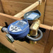 Angled view of Outdoor Living Today Raised Garden Bed Auto-Watering System timer and brass components on a wooden frame