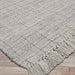 Angled view of the Couristan Ascot Indoor/Outdoor Rug - Windowpane/Linen highlights the clean grid texture and fringed border on a deck-style floor