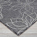 Angle of the Couristan Charm Indoor/Outdoor Rug - Botanical/Ash reveals clean edges and an elegant ash-and-white flower pattern on light wood floors