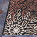 Another angle of Couristan Dolce Indoor/Outdoor Rug - Amalfi/Multi shows its crisp black edging and layered leaf motifs in soft neutral tones