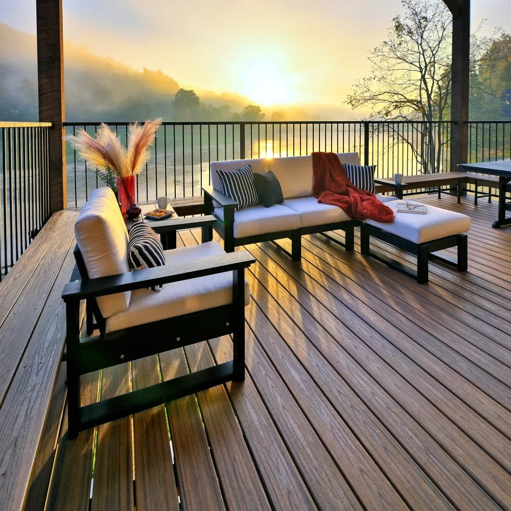 An outdoor poly lumber seating arrangement with cream cushions on a wooden deck, featuring a black finish LuxCraft Armrest.