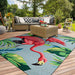 An outdoor seating area is styled with a large Couristan Covington Indoor/Outdoor Rug - Flamingos/Multi