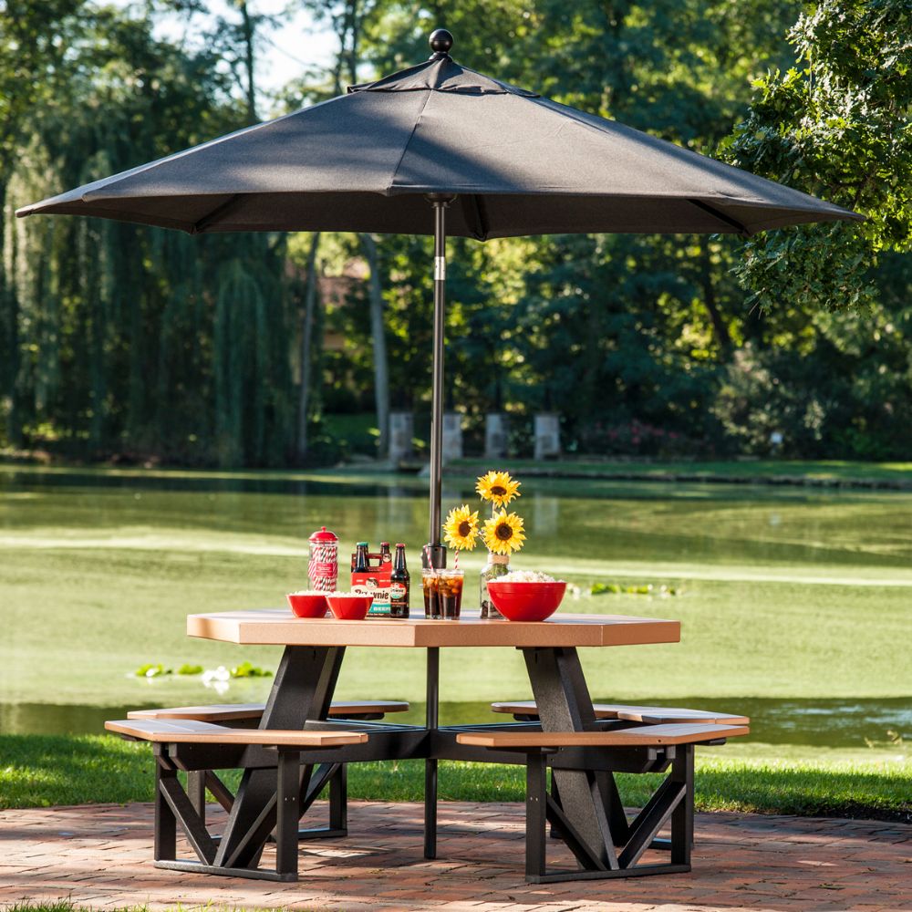 An outdoor table with a large umbrella supported by the LuxCraft Umbrella Frame Extension, providing extra height for more coverage and shade.