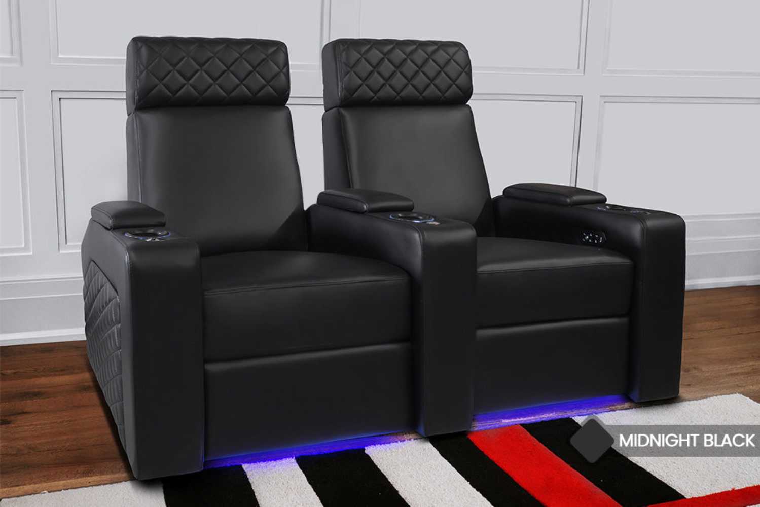 A pair of luxurious black Valencia Zurich Home Theater Seating chairs with quilted stitching and blue LED lighting